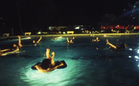 img4 Western expatriates take a break from humanitarian relief operations to practice 'aquatic yoga' at a plush club swimming pool off limits to ordinary Congolese people. Just one of the many perks of relief work in 'exotic' foreign war zones. Photo Keith Harmon Snow, 2007.