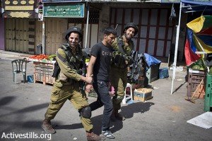 Israeli soldiers arrest a Palestinian youth.