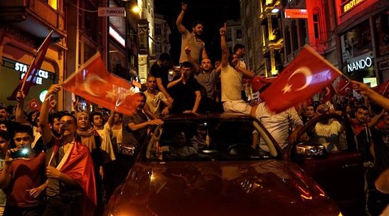 People chant slogans during a pro-government rally in central Istanbul's Taksim square,  July 16, 2016. Forces loyal to Turkish President Recep Tayyip Erdogan quashed a coup attempt in a night of explosions, air battles and gunfire that left some hundreds of people dead and scores of others wounded Saturday. (AP Photo/Bram Janssen)